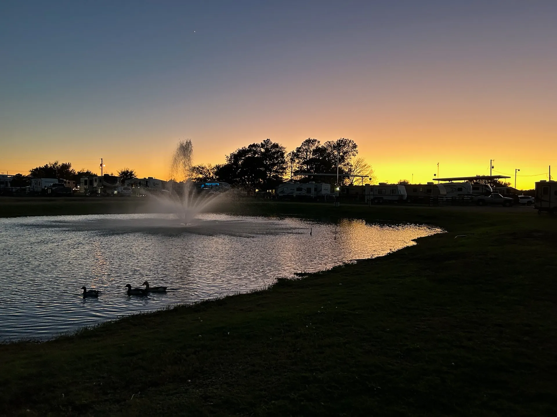 The pond fountain at golden hour · Waggin' Tail Ranch RV Resort, Pilot Point, Texas
