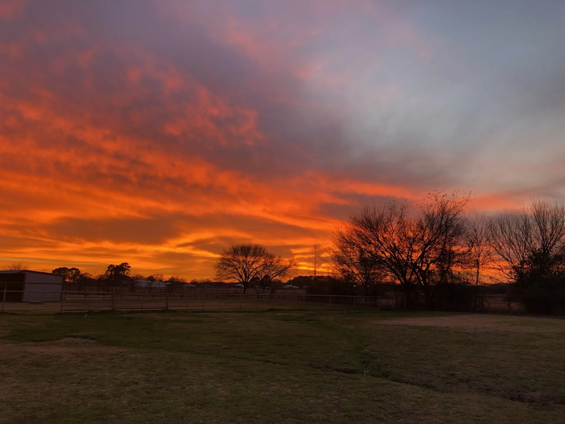 A blazing sunset over the ranch at Waggin' Tail Ranch RV Resort in Pilot Point, TX