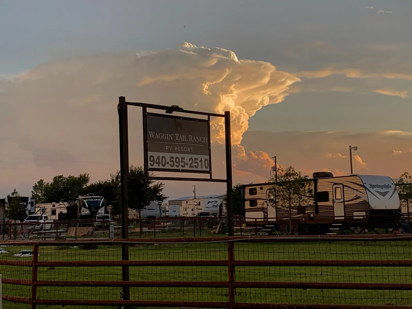 A towering thunderhead cloud behind the Waggin' Tail Ranch RV Resort sign in Pilot Point, TX horse country