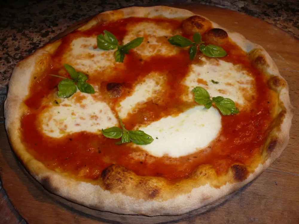 Fresh margherita pizza on a wooden peel