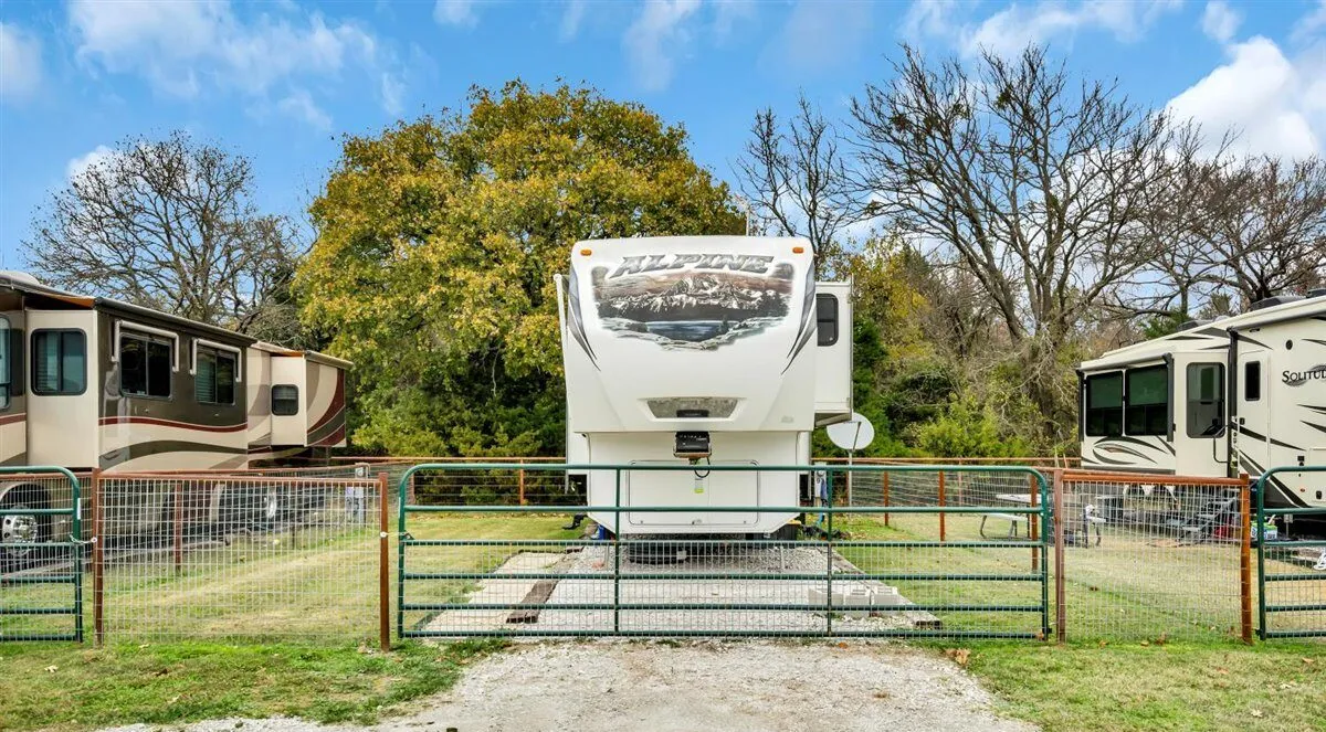 An individually fenced back-in RV site with private yard at Waggin' Tail Ranch RV Resort near DFW