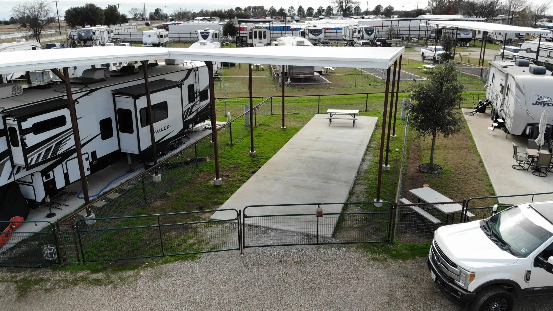 A covered RV site with fenced yard at Waggin' Tail Ranch RV Resort in North Texas